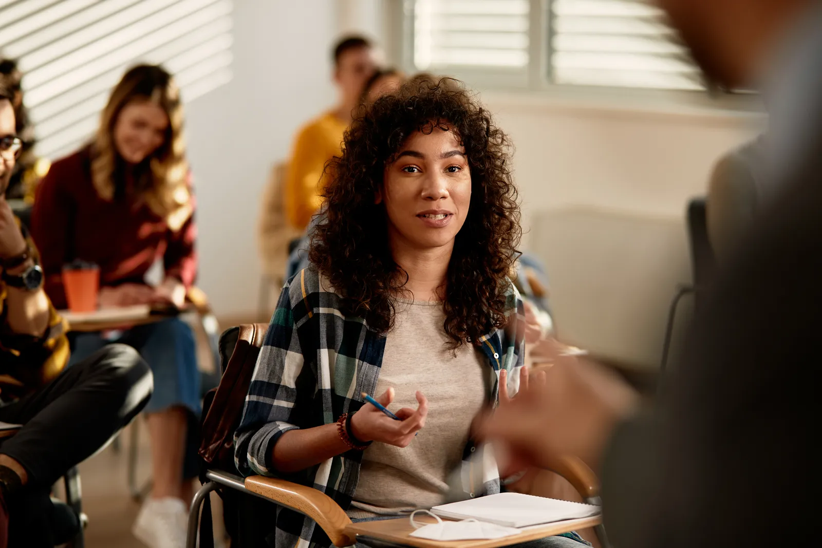 Docent in gesprek met een student tijdens een les