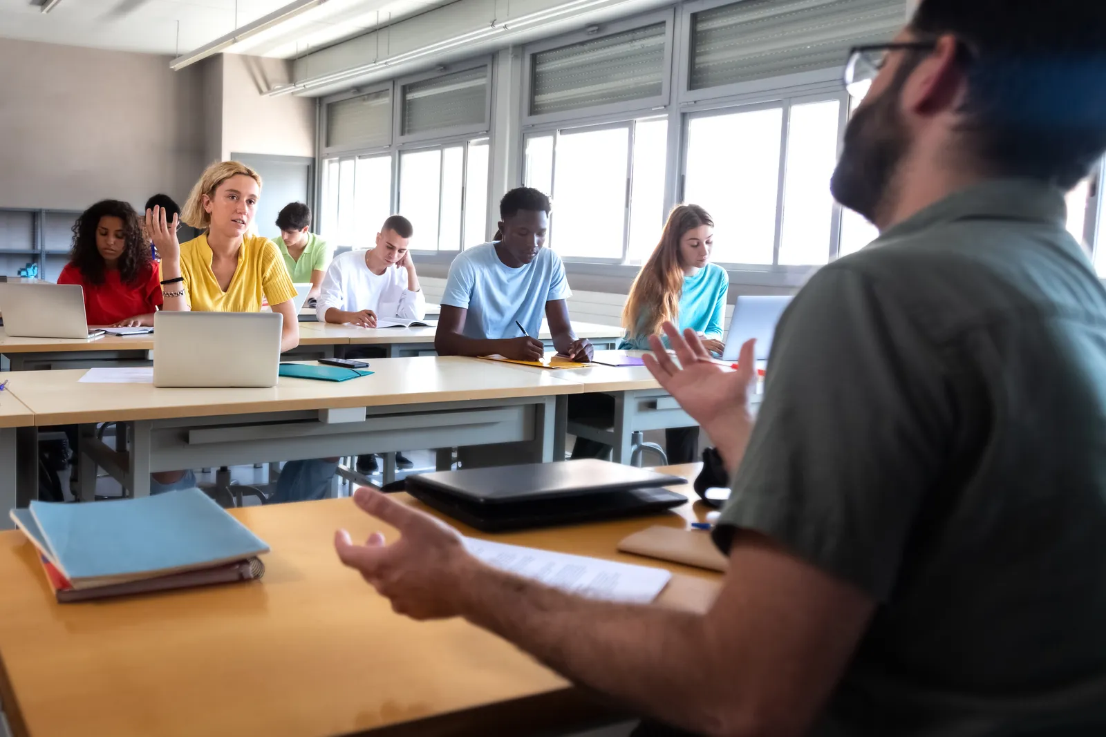Een docent in gesprek met een student in een klaslokaal