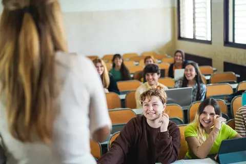 Lehrkraft schaut gemeinsam mit Lernenden Arbeit in der Stunde an