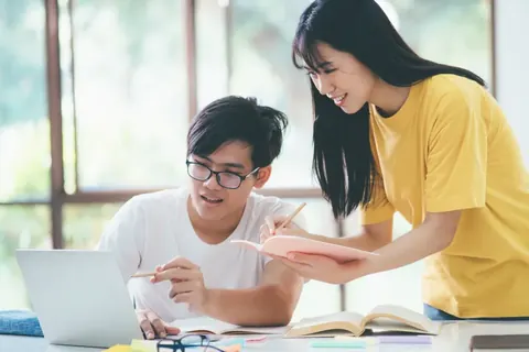 Students on campus helping a classmate catch up